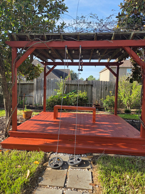 Custom red-stained backyard deck with pergola and built-in bench