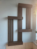 Dark-stained geometric wooden wall shelf mounted on a bathroom wall