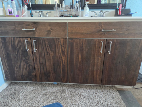 Double bathroom vanity with dark-stained wooden cabinet doors and drawers