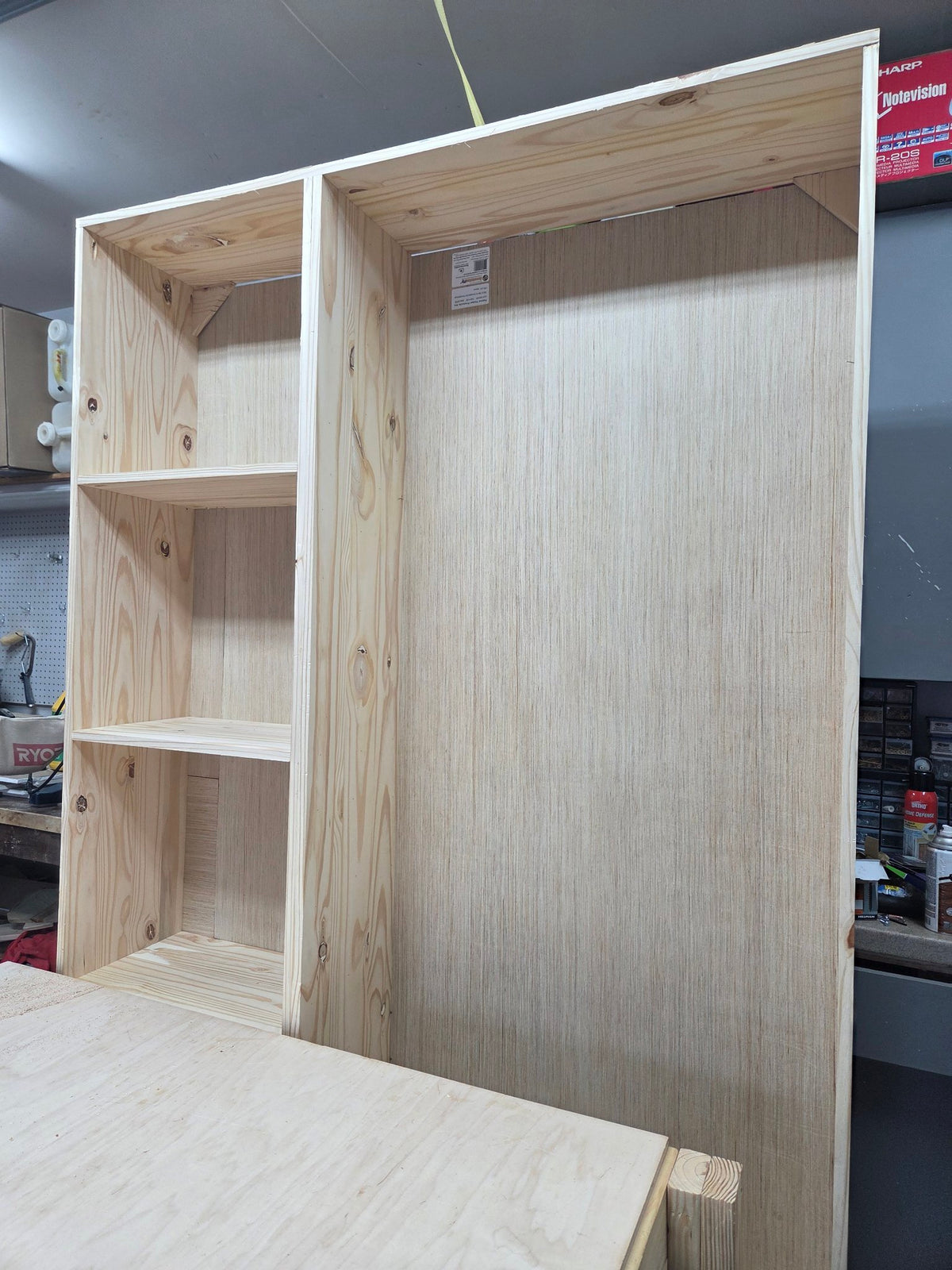 Tall solid pine storage cabinet with open shelves, shown unfinished in the workshop