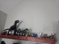 Rustic brown stained floating shelf displaying a dinosaur collection