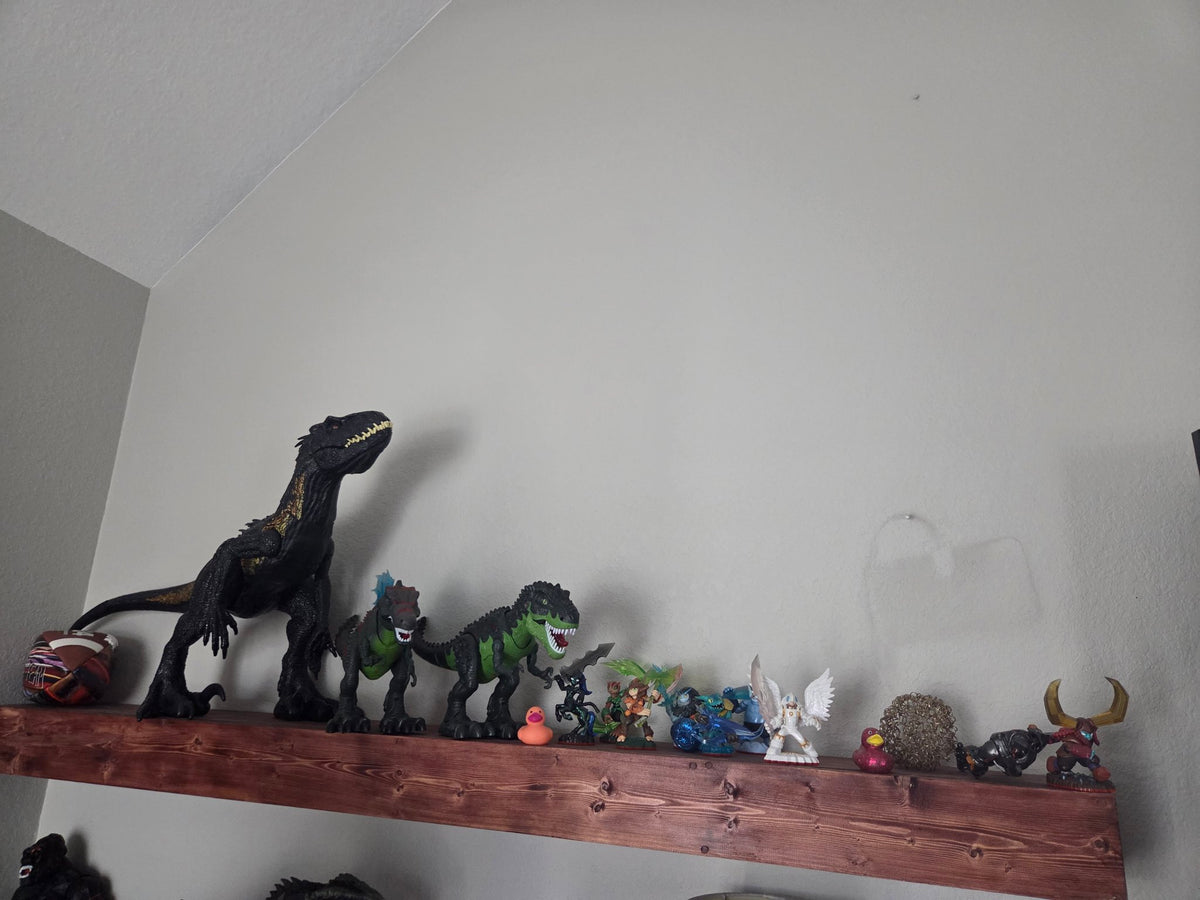 Rustic brown stained floating shelf displaying a dinosaur collection